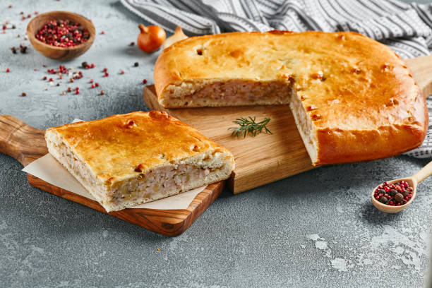 istock Classic chicken and potato pie on wooden board with ingredients. Composition with chicken pie on concrete background with textile and spices. Homemade pie with turkey and potato in rustic style. 1407837396