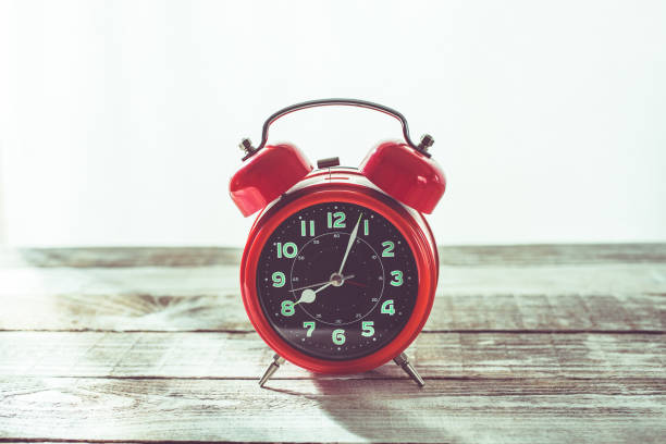 istock Red clock alarm clock retro design on a wooden table 1407838049