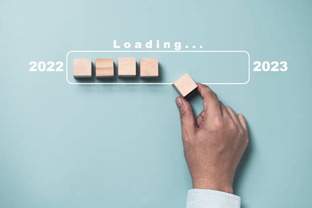 istock Hand putting wooden cube block for loading and update progress from 2022 to 2023 to preparation merry Christmas and happy new year concept. 1407838388