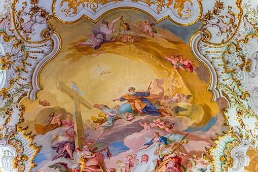 The majestic and stunning frescoed vault inside the church of Sant'Ignazio di Loyola (St. Ignatius of Loyola), in the historic and Baroque heart of Rome. The fresco, depicting the Glory of St. Ignatius, founder of the Society of Jesus (Jesuits), is one of the absolute masterpieces of the Roman Baroque. Painted by the artist Andrea Pozzo in 1685, this fresco almost entirely covers the vault of the church with a perspective representation that, between arches, clouds and columns, increases its space and volumes, effectively creating a virtual reality. The work depicts Christ (in the center) who radiates the figure of St. Ignatius and at the corners the allegories of the four continents known until then. In 1980 the historic center of Rome was declared a World Heritage Site by Unesco. Super wide angle image in high definition format.