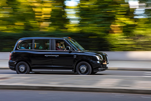 London, UK - August 12th 2021: An iconic black London Taxi travelling in central London, UK.