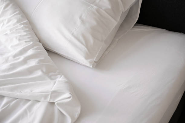 istock unmade bed with white linens close-up 1407841431