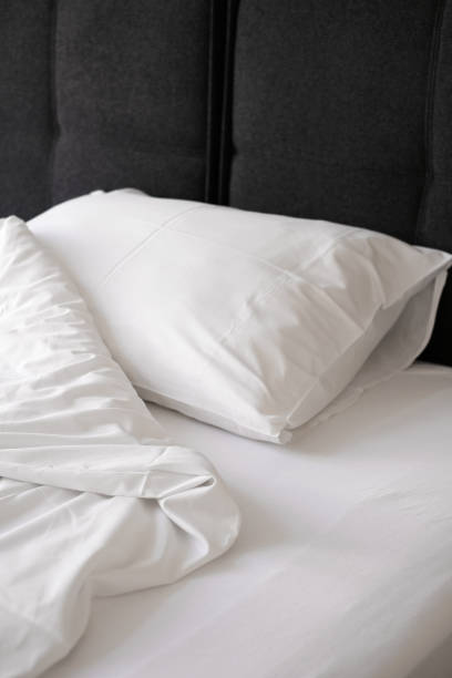 istock unmade bed with white linens close-up 1407841441