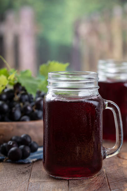 istock Glass of grape juice with rural background 1407843460