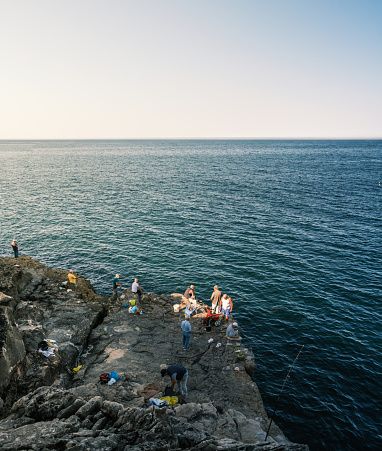 Cascais , Portugal; 10 July 2022: People fishing in the mouth of hell in Cascais