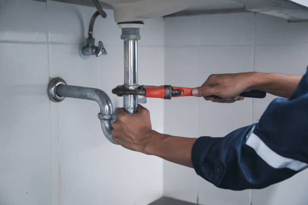 istock Male Plumber Using Wrench To Fix Leaking Sink In Home Bathroom. 1407847276