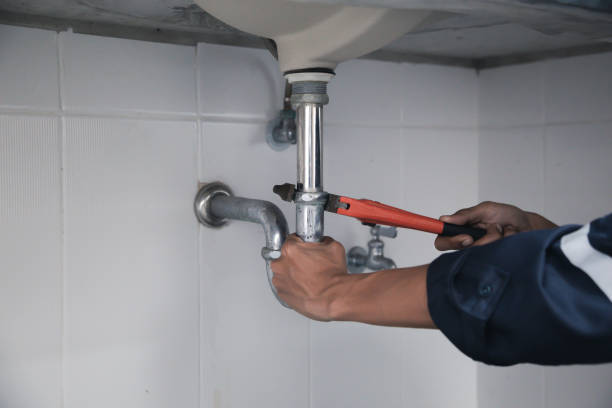 istock Male Plumber Using Wrench To Fix Leaking Sink In Home Bathroom. 1407847284