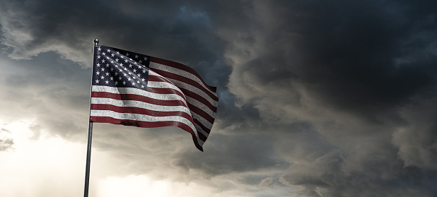american flag against a gloomy sky
