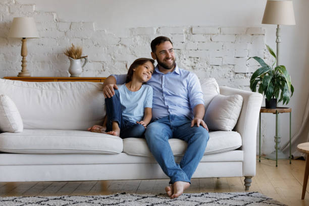 istock Peaceful father hugging little son relaxing on sofa at home 1407852367