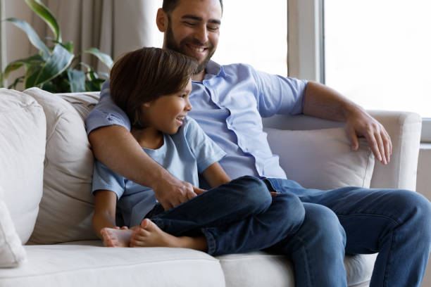 istock Happy dad and son resting sit on couch at home 1407852372