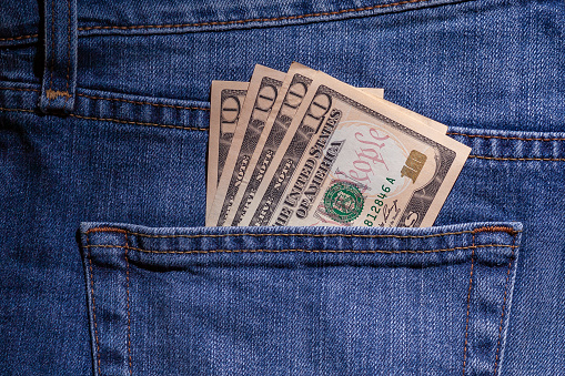 US Dollars in the blue jeans back pocket
