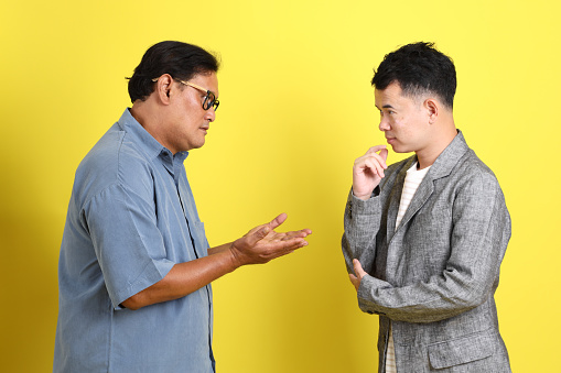 The adult two people standing on the yellow background.