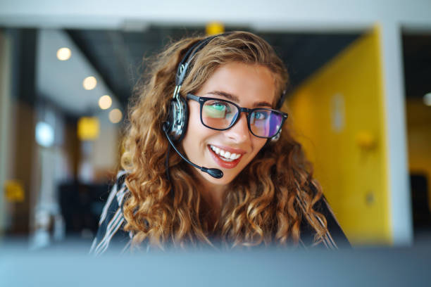 istock Female customer service representative in a headset is consulting clients online. 1407855846