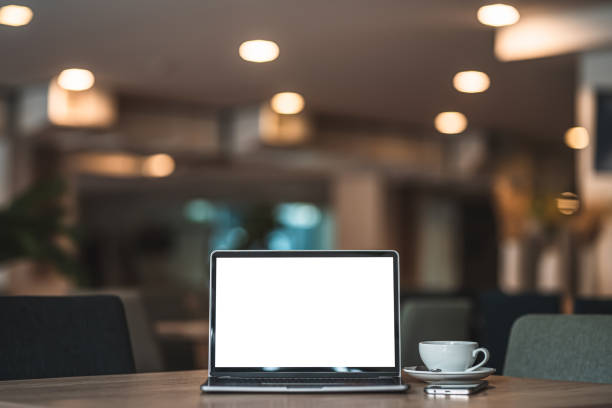 istock Mockup of laptop computer with empty screen with coffee cup and smartphone on table of the coffee shop background,White screen 1407857944
