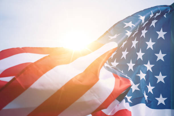 bandera de ee.uu. con luz solar de fondo - bandera estadounidense fotografías e imágenes de stock