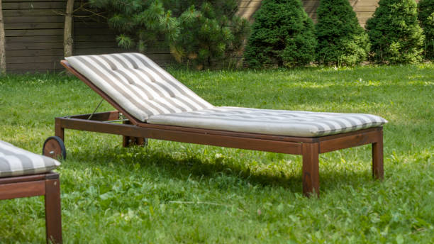 istock Lounge chairs on the backyard in a beautiful garden. Two empty sunbeds on the grass. 1407859759