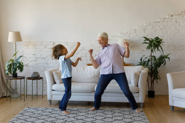 istock Lively older grandfather his grandson dancing at home 1407861973