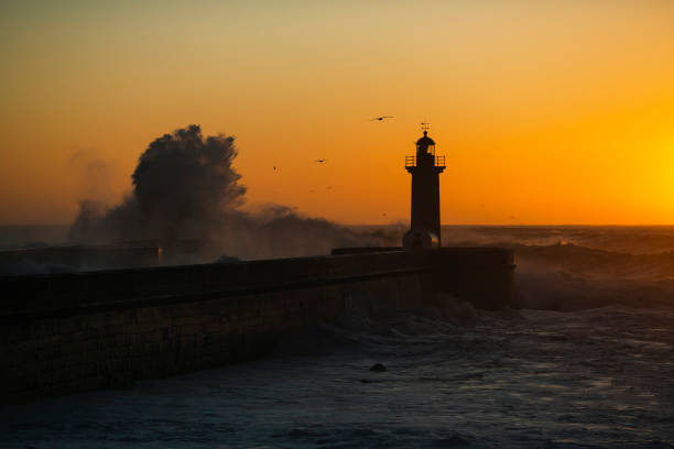 istock A silhouette of an ocean lighthouse, at dusk. 1407862012