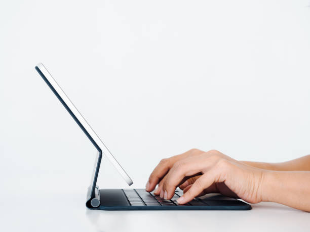 istock Hands typing on keyboard computer on digital tablet screen isolated on white background with copy space. Business and technology concept, side view. 1407862161