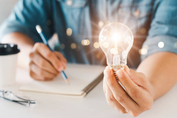 istock Innovation through ideas and inspiration ideas. Human hand holding light bulb to illuminate, idea of creativity and inspiration concept of sustainable business development. 1407862428