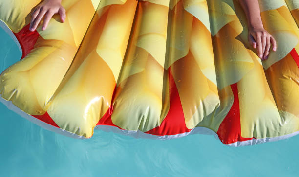 istock Boy or girl on an inflatable or Floating Sleeping Bed in a swimming pool 1407863121