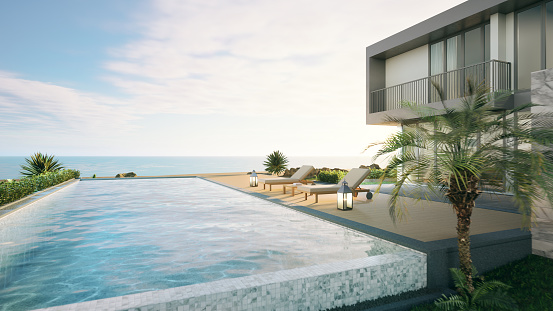 Luxury beach house with swimming pool,sun lougers and sea view in modern style.Concept for vacation real estate and property.3d rendering
