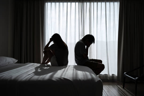 depressed couple having a problem sitting head in hands in the dark bedroom, negative emotion and mental health concept - relationship trouble imagens e fotografias de stock