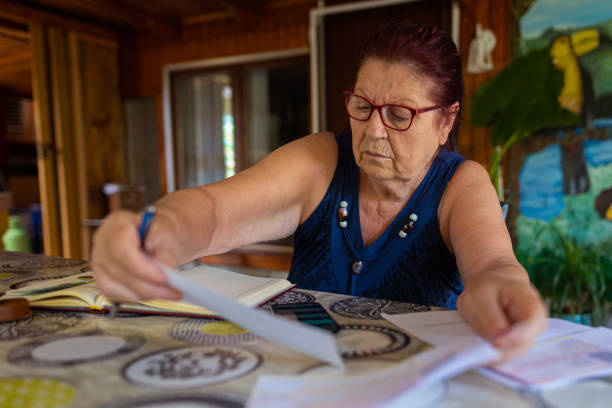 istock Serious old woman working at home 1407866200