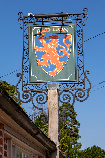 Suffolk, UK - September 7th 2021: The traditional pub sign outside the Red Lion public house in the beautiful village of East Bergholt in Suffolk, UK.