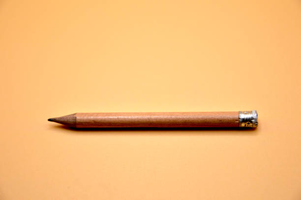 短い鉛筆ブラウン、オレンジの背景コンセプトのくぼみにシャープに貼り付けられていない学校用品学用品 - pencil office supply yellow sharp ストックフォトと画像