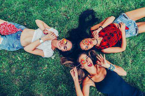 Relaxed women in the grass with lollipops