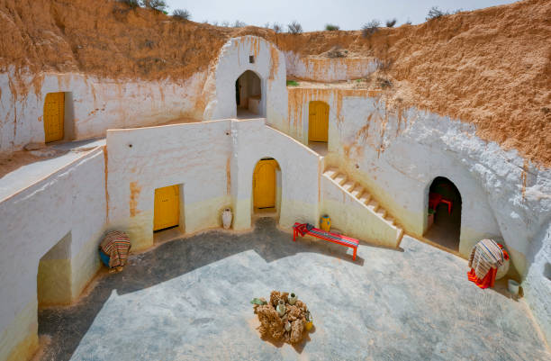 Berber Troglodyte house / cave dwelling in Matmata / Tunisia Matmata is a small Berber speaking town in southern Tunisia. Some of the local Berber residents live in traditional underground "troglodyte" structures. The structures typical for the village are created by digging a large pit in the ground. cliff dwelling stock pictures, royalty-free photos & images