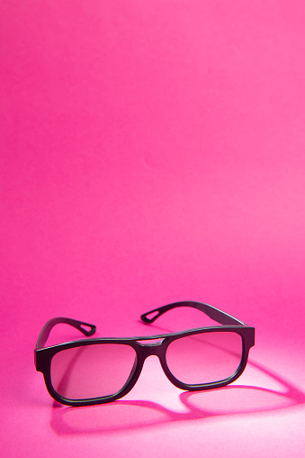 3D movie glasses on pink background.
