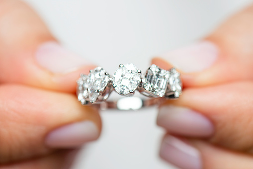 Hands showing diamond ring.