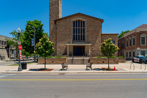 A Catholic Church in Bardstown, Kentucky is made out of red brick with a tall white steeple and pillars