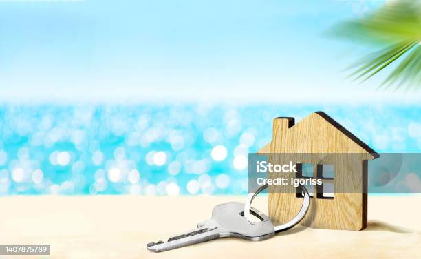 House By The Sea Concept Figure Of House And Key On Sandy Beach Stock Photo - Download Image Now
