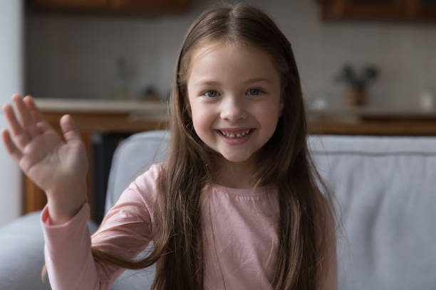istock Little girl raise arm makes hello gesture start video call 1407878148