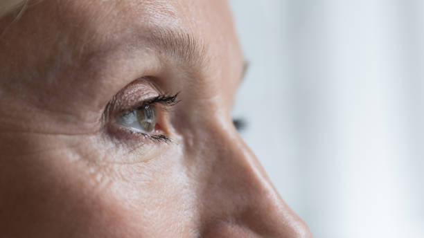 closeup shot face of senior woman eye looking into distance - wrinkles eyes imagens e fotografias de stock