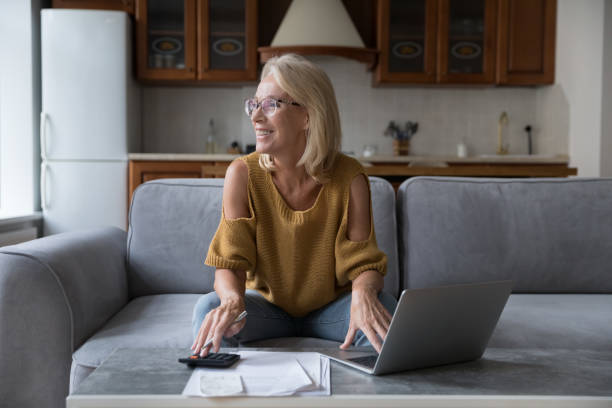 Happy older woman distracted from finances management smile staring aside