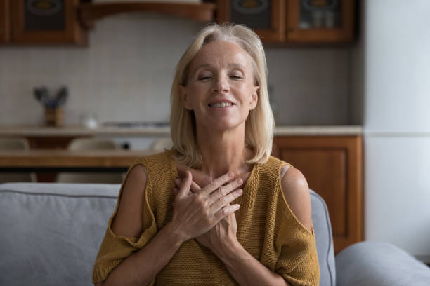 istock Smiling older female praying put folded arms on chest 1407879132