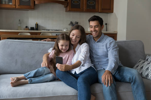 istock Happy family with daughter make video call using smart phone 1407879263