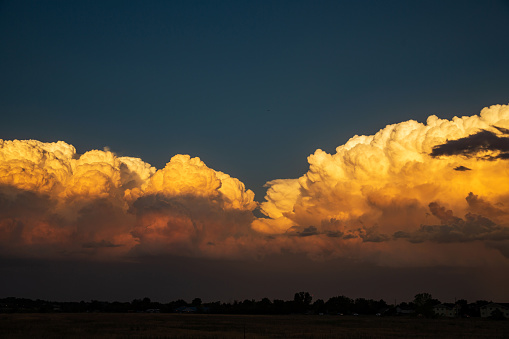 Thunderhead clouds form over the residential area during the summer evening