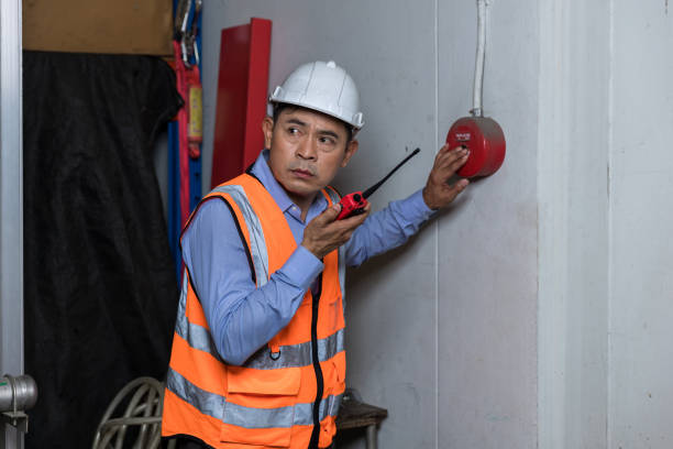 istock Foreman or worker pushing fire alarm on the wall. A fire! or Emergency case at the factory building. Emergency of Fire alarm or alert or bell warning equipment 1407886448