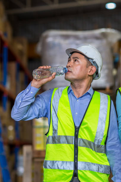 istock Worker drinking water in factory site. 1407887233