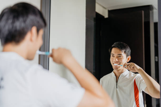 istock Young man brushes his teeth in bathroom 1407888370