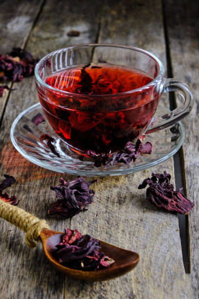 istock Cup karkade tea with bright red shade wooden background. 1407889374