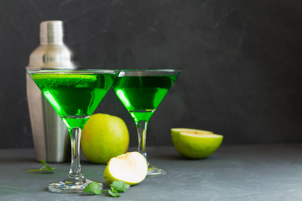 istock Apple cocktail mixed drink with vodka and apple slice. Apple martini cocktail on the black background. Green Alcoholic drinks in martini glasses with apple slice. copy space. 1407889453