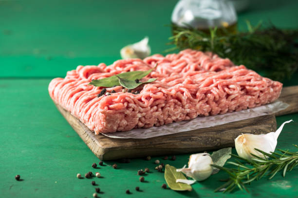 istock Raw Mince, minced Ground beef meat on a cutting board. Green background. Top view 1407889891