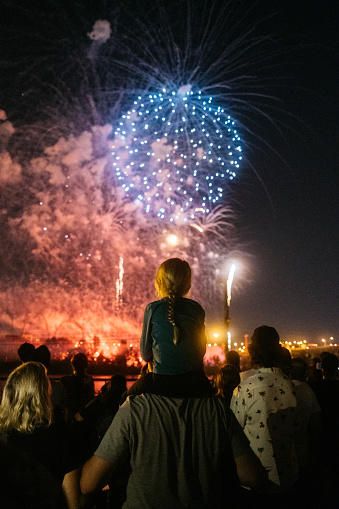 The opening night of L'International des Feux Loto-Québec, Montréal. A young girl is watching the show on her father's shoulders.