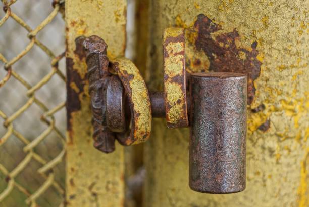 istock one big old brown iron padlock hanging on a rusty yellow metal door 1407892784